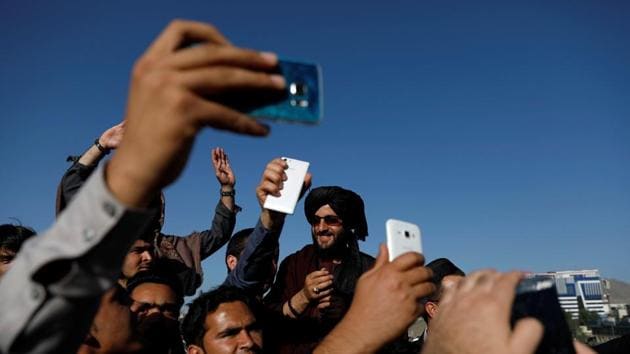 Afghans take pictures with Taliban members, Kabul, June 16(REUTERS)