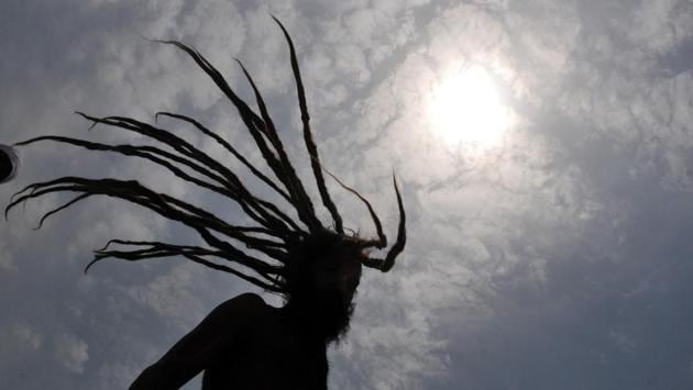 A sadhu dries his hair before heading for the cave shrine of Lord Shiva. (Nitin Kanotra/HT )