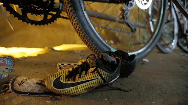 A pair of soccer shoes next to the abandoned bicycles belonging to the missing football team is seen at the entrance of a deep cave in northern Thailand while rescue personnel conduct operations under floodlights, seen in the background. Twelve children and their coach have been missing for four days since they entered the sprawling Tham Luang cave Saturday afternoon, after a morning intra squad match nearby. (Thai News Pix / AP) A pair of soccer shoes next to the abandoned bicycles belonging to the missing football team is seen at the entrance of a deep cave in northern Thailand while rescue personnel conduct operations under floodlights, seen in the background. Twelve children and their coach have been missing for four days since they entered the sprawling Tham Luang cave Saturday afternoon, after a morning intra squad match nearby. (Thai News Pix / AP)