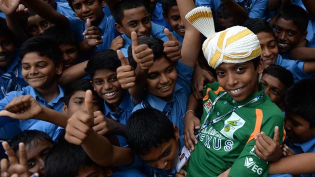 Indian chess prodigy Rameshbabu Praggnanandhaa(R), 12, is celebrated by his school friends upon his arrival back to his school in Chennai on Tuesday after becoming the world's second youngest chess grandmaster ever. (Arun Sankar / AFP File)