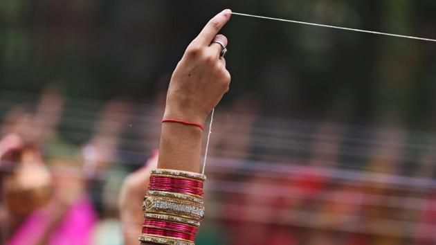 A married Hindu woman ties cotton thread around a Banyan tree as she performs a ritual on "Vat Savitri festival", which is celebrated on a full moon day, when married women fast and pray for their husbands' health and longevity. (Amit Dave / REUTERS)