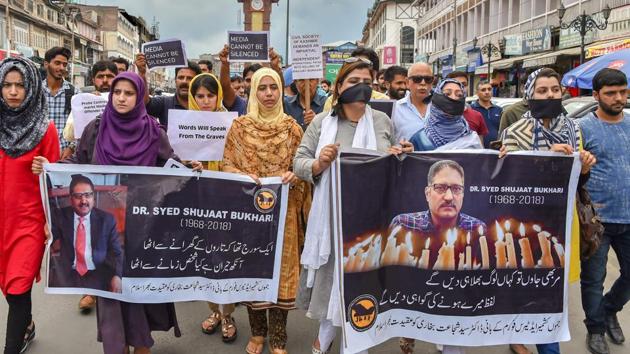 Journalists hold placards during a silent protest march against the killing of Rising Kashmir newspaper editor-in-chief Shujaat Bukhari, in Srinagar on Tuesday.(PTI)