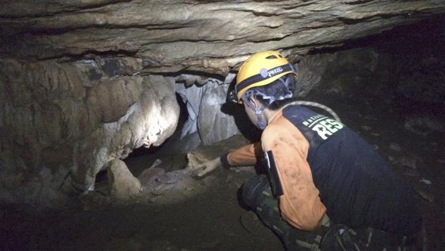 A rescue personnel searches for alternate entrances into the cave. Workers took turns pumping water from inside the cave, which runs 10kms under a mountain of Chiang Rai, but persistent heavy rain was compounding difficulties. (Thailand Department of National Parks and Wildlife / AP) A rescue personnel searches for alternate entrances into the cave. Workers took turns pumping water from inside the cave, which runs 10kms under a mountain of Chiang Rai, but persistent heavy rain was compounding difficulties. (Thailand Department of National Parks and Wildlife / AP)