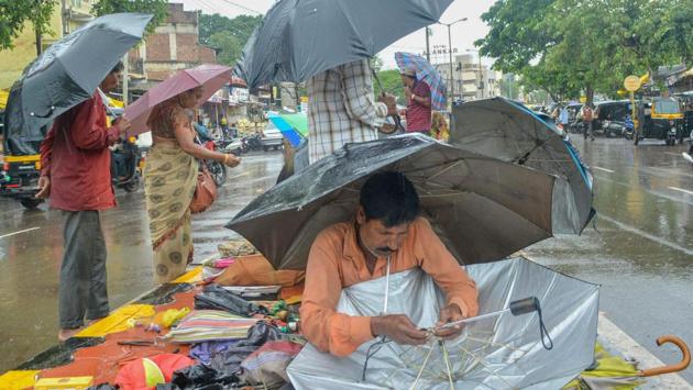 A man repairs an umbrella as it rains, in Maharashtra’s Karad, on Tuesday. The monsoon lashed several parts of the state, a development welcomed by Nashik farmers who were waiting for a spell of showers to start sowing operations in their fields. (PTI)