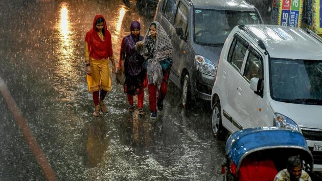 Pedestrians try to make their way across a street during heavy rain, in Lucknow on Tuesday. Forecasts of rain and thunderstorms at most places in the state on June 28 and June 29 are in place. The monsoon also advanced into most parts of Bihar yesterday, triggering light to moderate rainfall at a few places in the state. (Nand Kumar / PTI)