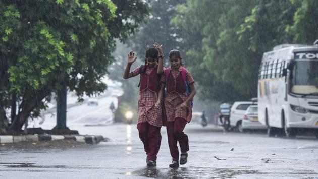 Children leave for school during pre-monsoon showers in New Delhi. Very light rain was reported in some parts of the NCR today. The monsoon rains are expected to arrive on Thursday with fairly widespread rainfall and sustained easterly winds bringing moisture from the Bay of Bengal. (Burhaan Kinu / HT Photo)