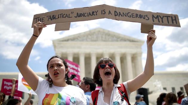 Protesters Celina Scott-Buechler (R) and Lisset Pino (L) demonstrate against Trump's travel ban. The ban was one of Trump’s signature hardline immigration policies that have been a central part of his presidency and “America First” approach. Trump issued his first version just a week after taking office, though it was quickly halted by the courts. (Win McNamee / Getty Images / AFP)