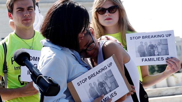 Michelle Edralin, 12, is comforted as immigration rights proponents react outside the Supreme Court. The ruling affirmed broad presidential discretion over who is allowed to enter the US. It means that the current ban can remain in effect and that Trump could potentially add more countries to it. (Leah Millis / REUTERS)