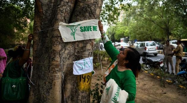 A woman puts up a banner on a tree during the ‘Save The Tree Campaign’ in New Delhi on June 26, 2018. Residents of Delhi launched the campaign to save more then 16.000 trees to be cut for a redevelopment project. (AFP) A woman puts up a banner on a tree during the ‘Save The Tree Campaign’ in New Delhi on June 26, 2018. Residents of Delhi launched the campaign to save more then 16.000 trees to be cut for a redevelopment project. (AFP)