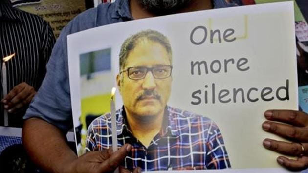 Journalists participate in a silent protest against the brutal killing of a senior Kashmiri journalist Shujaat Bukhari, portrait seen, in Kolkata, June 15, 2018.(AP File Photo)