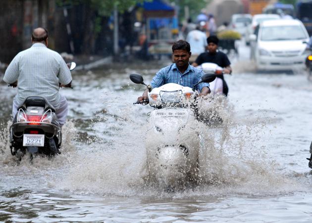 Vehicles wade through water-logged road after monsoon arrived in Jalandhar. (Pardeep Pandit/HT)