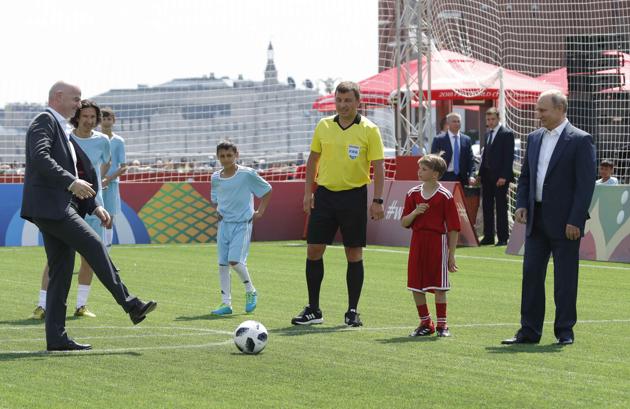 Russian President Vladimir Putin (R) and FIFA President Gianni Infantino (L) take part in the opening of an exhibition soccer match in the World Cup Football Park in Red Square in central Moscow, Russia on June 28, 2018(REUTERS)