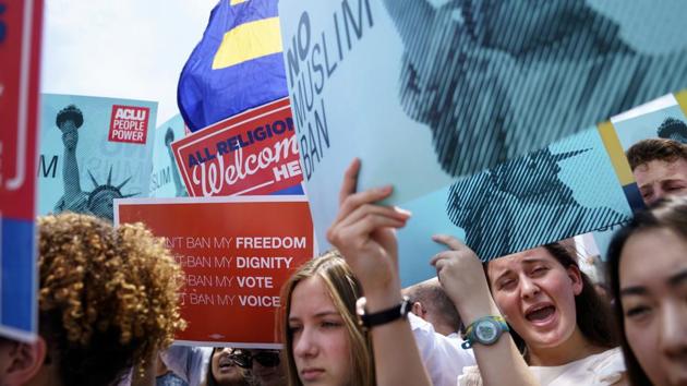 Protesters hold placards as they call out against the Supreme Court ruling. The Trump policy applies to travellers from five countries with a large Muslim population --Iran, Libya, Somalia, Syria and Yemen. It also affects two non-Muslim countries, blocking travellers from North Korea and some Venezuelan government officials and their families. (Carolyn Kaster / AP)