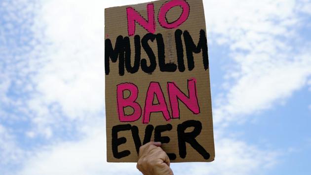 A protester holds a sign that reads "No Muslim Ban Ever." Critics of Trump’s ban had urged the justices to affirm decisions in lower courts that generally concluded that the changes made to the travel policy didn’t erase the ban’s legal problems. (Carolyn Kaster / AP)