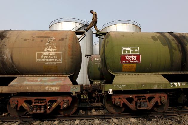 A worker walks atop a tanker wagon to check the freight level at an oil terminal on the outskirts of Kolkata, India.(REUTERS File Photo)