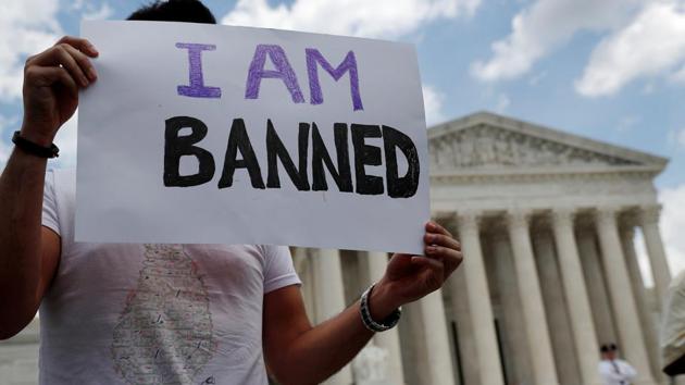 Mehrad Ansari of Iran holds a placard outside the Supreme Court. He and his sister both attend university in the US and now may not go home to see their family in Iran if they want to be able to return to the US. The court held that the challengers had failed to show that the ban violates either US immigration law or the US Constitution’s First Amendment prohibition on the government favouring one religion over another. (Leah Millis / REUTERS)