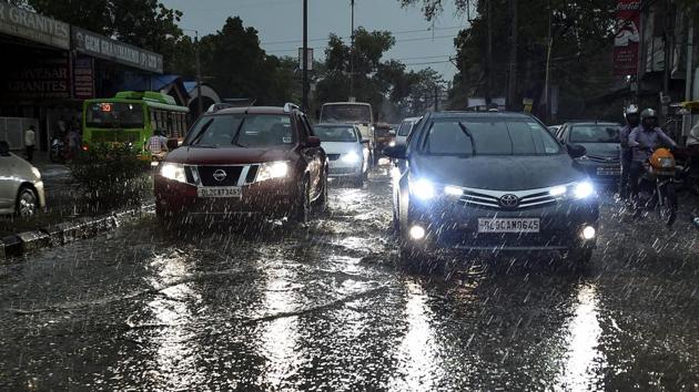 Vehicles ply on a road as it rains in New Delhi. (PTI Photo)