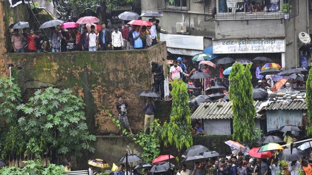 Rescue officials and witnesses at the crash site in Ghatkopar, Mumbai.(Vijayanand Gupta/HT Photo)