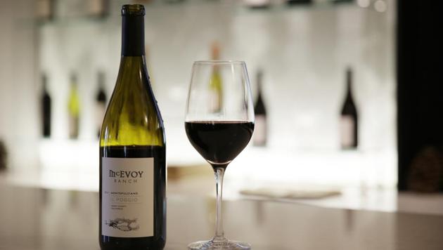 A glass and bottle of McEvoy Ranch Il Poggio Montepulciano wine stand on a tasting room counter at the winery in Petaluma, California. The ranch is located in Northern California’s Petaluma Gap which is one of America’s newest viticultural areas and among the go-to places for wineries and vineyards hedging their bets against climate change. The area’s slogan: “From wind to wine.” (Eric Risberg / AP) A glass and bottle of McEvoy Ranch Il Poggio Montepulciano wine stand on a tasting room counter at the winery in Petaluma, California. The ranch is located in Northern California’s Petaluma Gap which is one of America’s newest viticultural areas and among the go-to places for wineries and vineyards hedging their bets against climate change. The area’s slogan: “From wind to wine.” (Eric Risberg / AP)