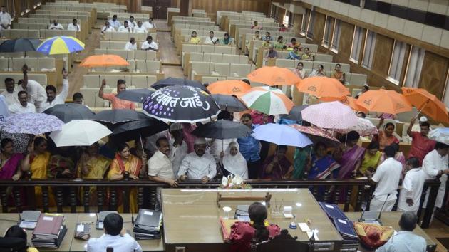 Members of the Shiv Sena, Congress and Nationalist Congress Party(NCP) protest with umbrellas in front of Mukta Tilak, mayor, on the issue of water leakage in the new Pune municipal corporation building, during the general body meeting on Thursday. (RRAVINDRA JOSHI/HT PHOTO) Members of the Shiv Sena, Congress and Nationalist Congress Party(NCP) protest with umbrellas in front of Mukta Tilak, mayor, on the issue of water leakage in the new Pune municipal corporation building, during the general body meeting on Thursday. (RRAVINDRA JOSHI/HT PHOTO)