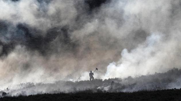 A firefighter works at a fire on a moor above Carrwood, England. (Phil Noble / REUTERS) 