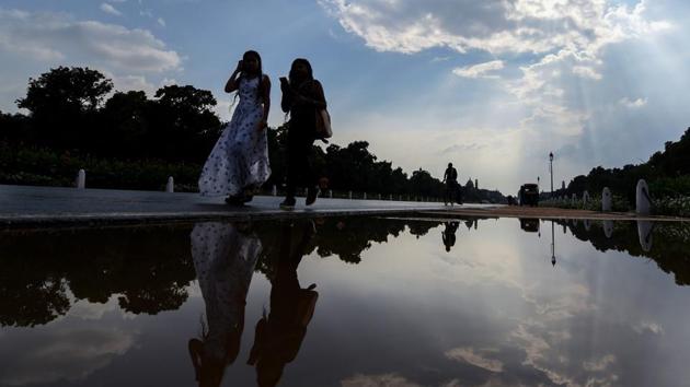 Women walk past a puddle of water at Rajpath after a short spell of rain in New Delhi on Thursday.(PTI Photo) Women walk past a puddle of water at Rajpath after a short spell of rain in New Delhi on Thursday.(PTI Photo)