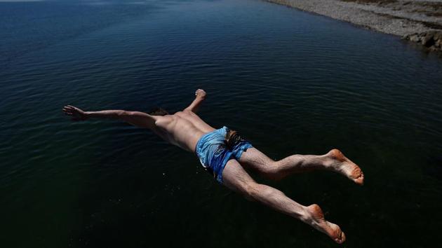 A man jumps into the sea at Salthill beach during sunny weather in Galway, Ireland. (Clodagh Kilcoyne / REUTERS) 