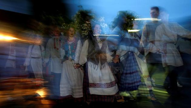 People in national Belarussian clothes dance as they take part in the Ivan Kupala festival, which celebrates the summer solstice, near the town of Oktyabrski, Belarus. (Vasily Fedosenko / REUTERS) 
