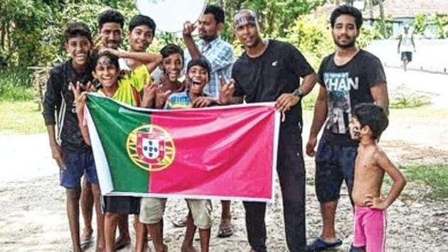 Youths of Mirpur, a village in West Bengal, with the flag of Portugal. They are gunning for Cristiano Ronaldo at the FIFA World Cup.(HT Photo)