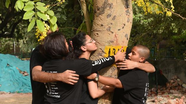 People hug a tree as they protest against the felling of trees at Sarojini Nagar in New Delhi on June 24, 2018. (Sonu Mehta / HT Photo) People hug a tree as they protest against the felling of trees at Sarojini Nagar in New Delhi on June 24, 2018. (Sonu Mehta / HT Photo)