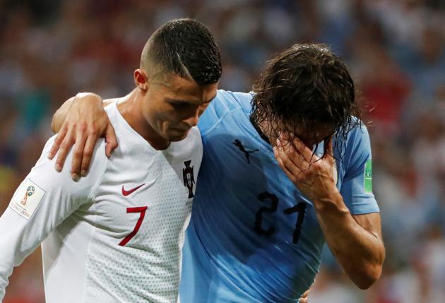 Portugal's Cristiano Ronaldo helps Uruguay's Edinson Cavani. (REUTERS) Portugal's Cristiano Ronaldo helps Uruguay's Edinson Cavani. (REUTERS)
