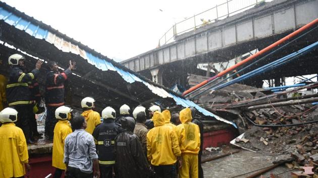 A part of a footover bridge collapsed at Andheri station in Mumbai on Tuesday morning following heavy rain hitting suburban local train services. Five people were injured in the mishap, two of them with serious injuries, and were admitted to Cooper hospital in Juhu. Meanwhile, waterlogging was reported from several parts of the city resulting in traffic jams. (Satyabrata Tripathy / HT Photo)