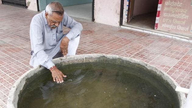 Karam Singh Tanwar whose wife died of cancer shows the poor quality of the village’s borewell water. Tanwar ,who along with Chand carried out an informal survey to ascertain the nature and extent of cancer prevalence, said that he had managed to identify at least a dozen families in Bandwari who have lost a member to cancer over the last year and a half. (Yogendra Kumar / HT Photo)