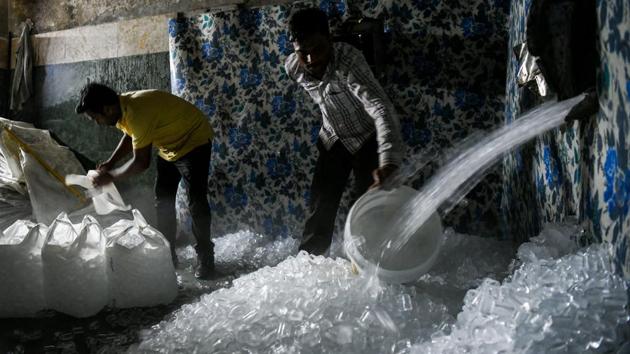 If not sold to clients, the blocks go into large machines that break them up and churn out thousands upon thousands of ice cubes that are gathered into bags, sent out for delivery and scooped into the drinks of thirsty Delhiites. (Chandan Khanna / AFP) If not sold to clients, the blocks go into large machines that break them up and churn out thousands upon thousands of ice cubes that are gathered into bags, sent out for delivery and scooped into the drinks of thirsty Delhiites. (Chandan Khanna / AFP)