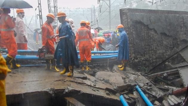 Rescue workers clear the debris of a foot overbridge that collapsed on the Western Railway tracks, at Andheri station following heavy rain in Mumbai.(PTI Photo)