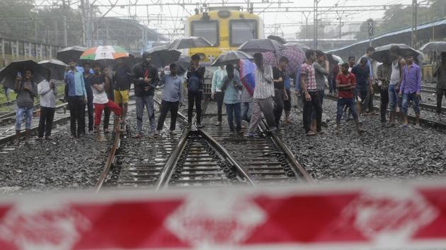 Commuters watch rescuers work at the site of a pedestrian bridge that collapsed at a train station in Mumbai on July 3, 2018. Part of a pedestrian bridge at a Mumbai train station collapsed Tuesday morning during heavy rains.(AP)