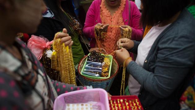 Vendors sell necklaces, bracelets and rings made of amber in Danai, Kachin state. Leaflets dropped by army helicopters in June last year even warned people living around the mines to leave the area or be considered to be cooperating with the rebels, according to Human Rights Watch. Now only the hardiest of amber hunters attempt to go there. (Ye Aung Thu / AFP) 
