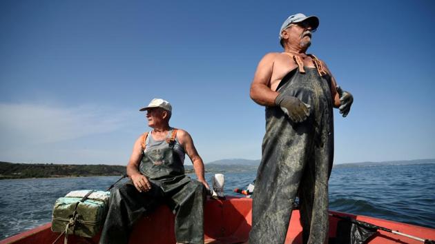 Panagiotis Pagonis (L) on the deck of his fishing boat off Asprovalta in northern Greece, grimaces at another empty catch. “It’s all gone to hell,” the 72-year-old muttered as the early glimmer of dawn lit up the waters. (Alexandros Avramidis / REUTERS)