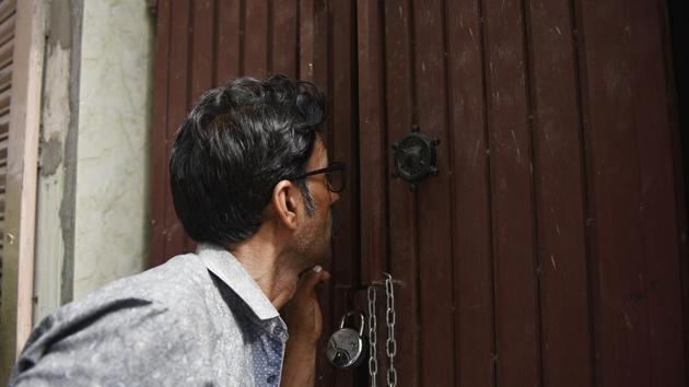 A man peeps at the house where 11 members of a family were found dead in Burari, north Delhi, on July 1.(Sanchit Khanna/HT Photo)