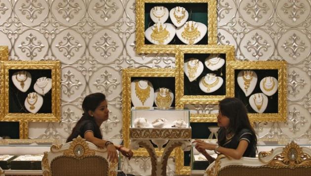 Employees wait for customers inside a gold jewellery showroom in New Delhi.(Reuters File Photo)