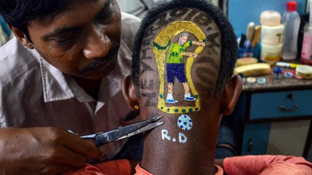A barber trims the hair of a Brazil football team fan after the team won a match against Mexico during FIFA World Cup 2018 Round of 16. (PTI)