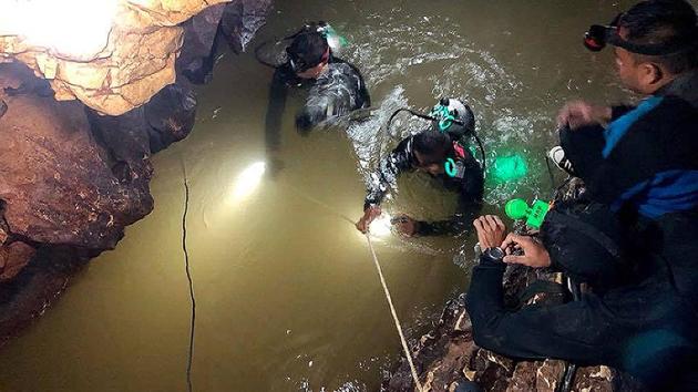 Divers inspect the water-filled tunnel in the cave. Diving would be the fastest, but arguably most dangerous, extraction. Getting the boys out could go faster due to the installation of dive lines, extra oxygen tanks left along the way and glow sticks lighting the path. Still, the British Cave Rescue Council has said that there are significant technical challenges and risks to consider. (AFP)