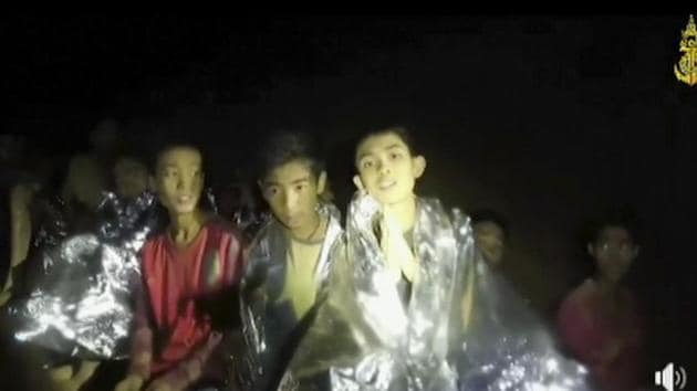 Image taken from video provided by the Thai Navy Seal shows boys with Navy SEALs inside the cave, in Mae Sai, northern Thailand.(AP Photo)