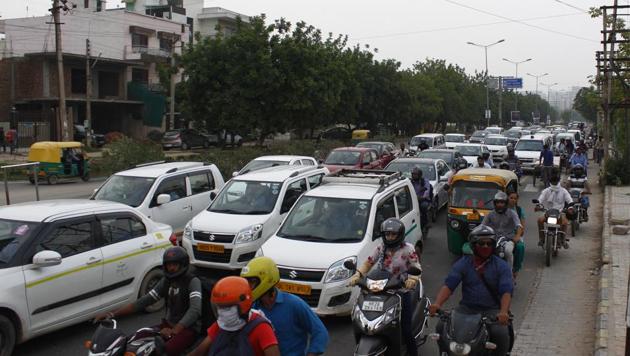 Travellers wait for signal to turn green at Paras Road signal, Kanhaiya Chowk in Gurugram, Haryana. Experts said it is easy to reach Gurugram from Delhi but harder to travel within the city due to limited commute options. (Yogendra Kumar/HT PHOTO) Travellers wait for signal to turn green at Paras Road signal, Kanhaiya Chowk in Gurugram, Haryana. Experts said it is easy to reach Gurugram from Delhi but harder to travel within the city due to limited commute options. (Yogendra Kumar/HT PHOTO)