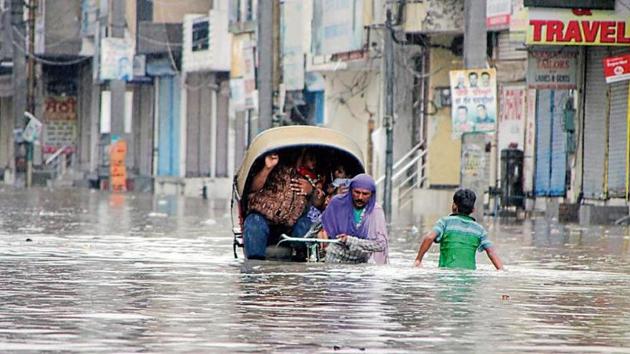 A rickshaw-puller wades through the waterlogged street in Bathinda. (HT Photo) A rickshaw-puller wades through the waterlogged street in Bathinda. (HT Photo)
