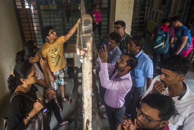 Students and parents check the first merit list of FYJC at Ruia College, Matunga on Thursday.(Pratik Chorge/HT Photo) Students and parents check the first merit list of FYJC at Ruia College, Matunga on Thursday.(Pratik Chorge/HT Photo)
