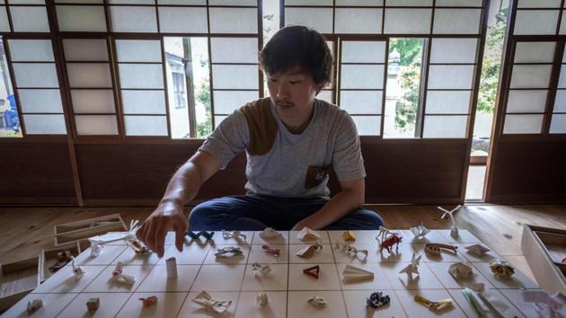Yuki Tatsumi sits next to his collection of origami made from chopstick sleeves in Kameoka, Kyoto prefecture. (AFP) Yuki Tatsumi sits next to his collection of origami made from chopstick sleeves in Kameoka, Kyoto prefecture. (AFP)