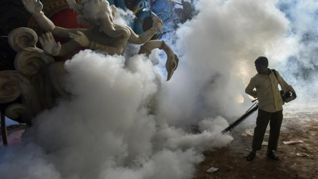 A BMC worker fumigates a Ganpati workshop at Vile Parle in Mumbai on July 2, 2018. (Kunal Patil / HT Photo)