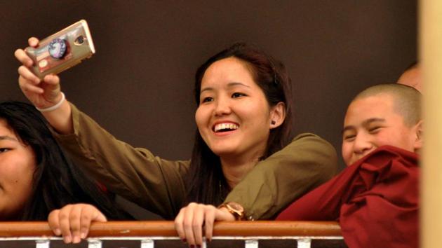 A woman takes photographs of the celebrations at Lha Gyari Temple in McLeodganj. The Dalai Lama fled Tibet after a failed uprising against the Chinese rule in 1959. He has been based out of India ever since. (Shyam Sharma / HT Photo) 