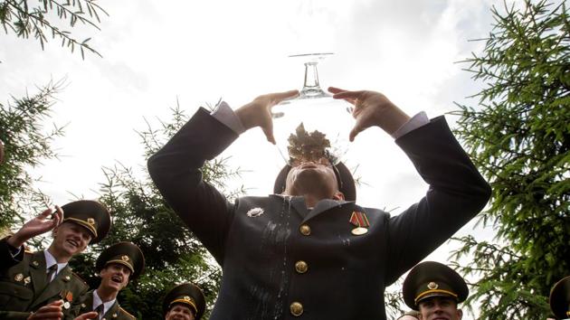 Graduates drink champagne as they celebrate after receiving diplomas at the Military Academy of Belarus in Minsk, Belarus. (Vasily Fedosenko / REUTERS)